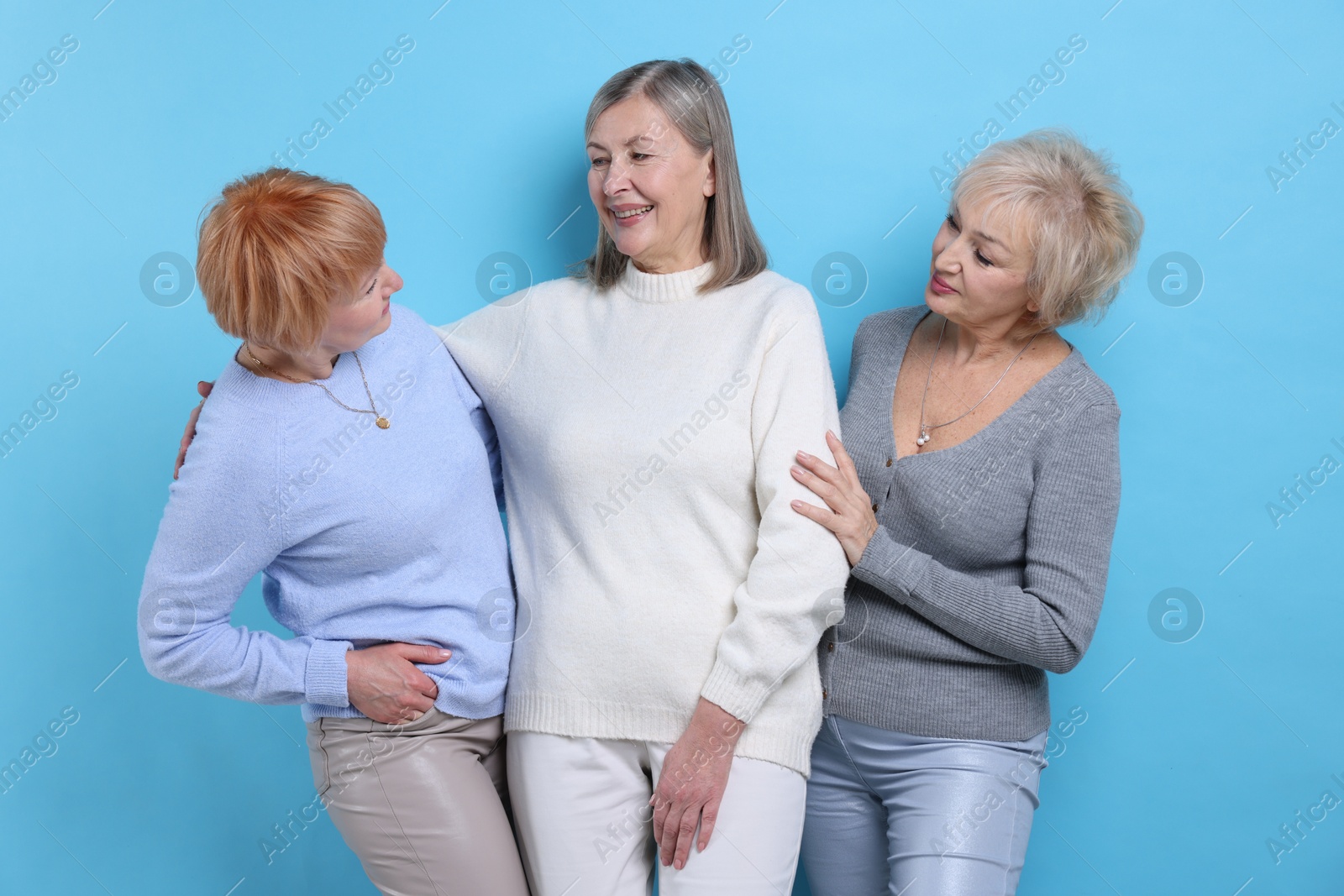 Photo of Friendship. Portrait of senior women on light blue background