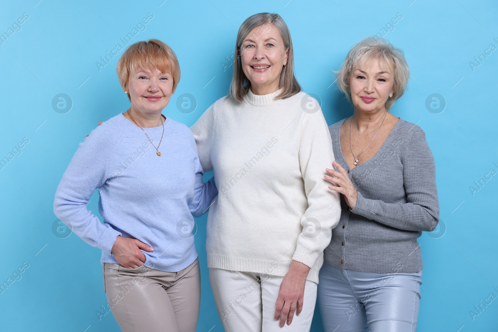 Photo of Friendship. Portrait of senior women on light blue background