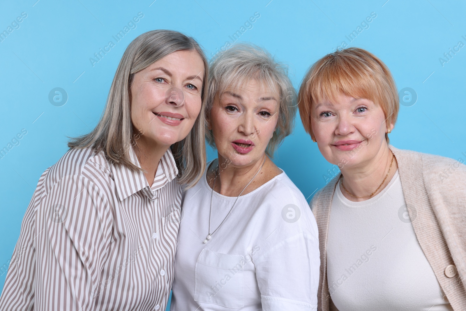 Photo of Friendship. Portrait of senior women on light blue background