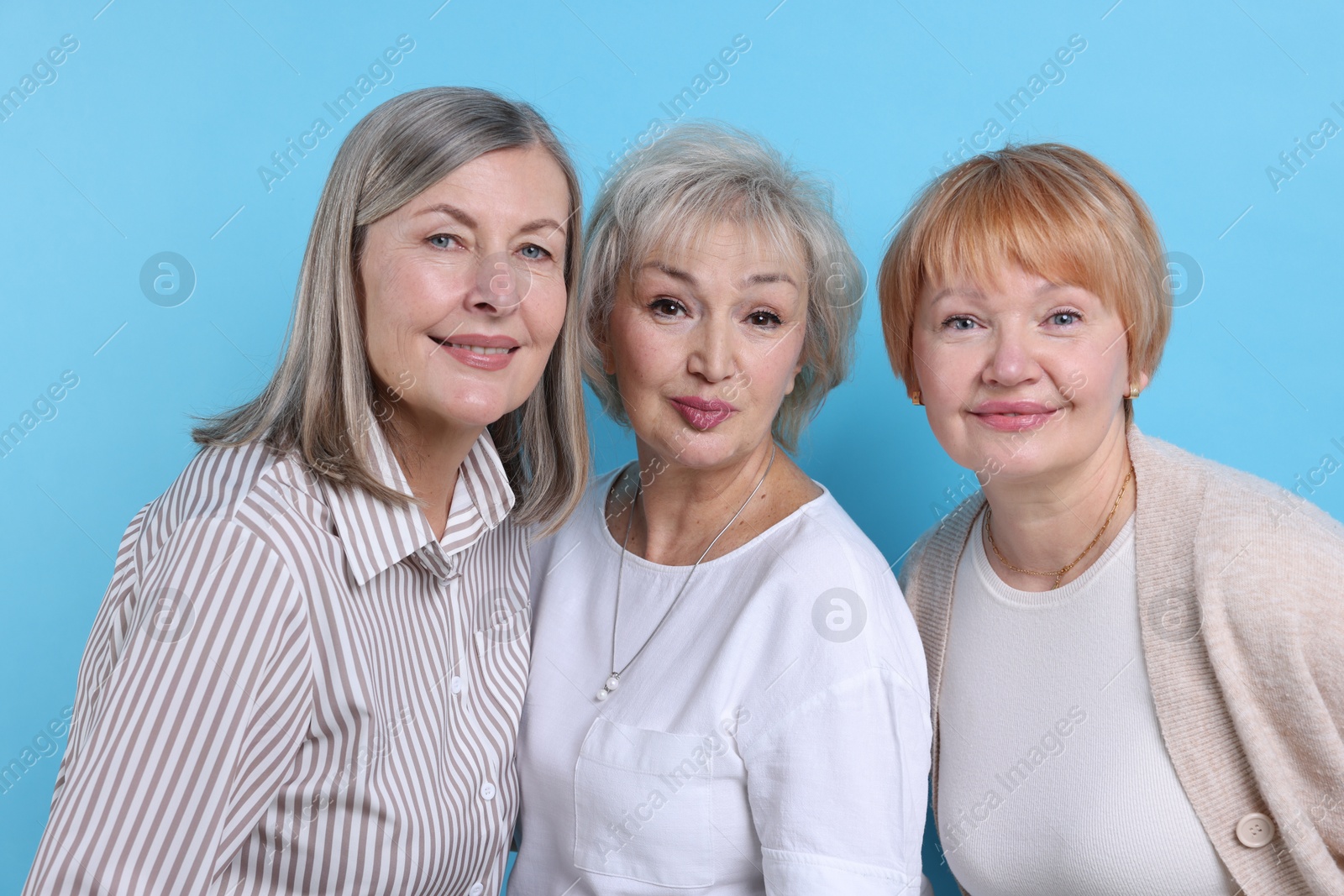 Photo of Friendship. Portrait of senior women on light blue background