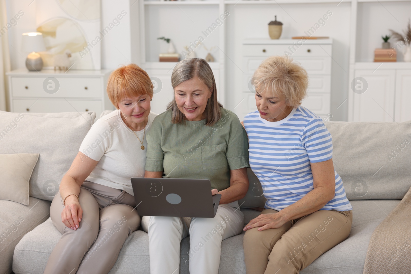 Photo of Friendship. Senior women watching something on laptop at home