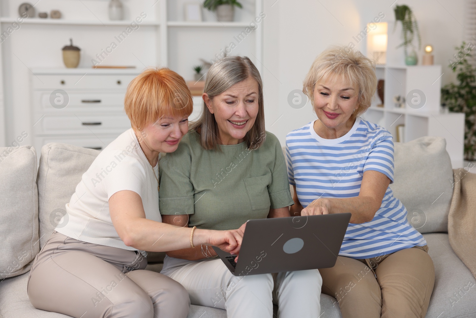 Photo of Friendship. Senior women watching something on laptop at home