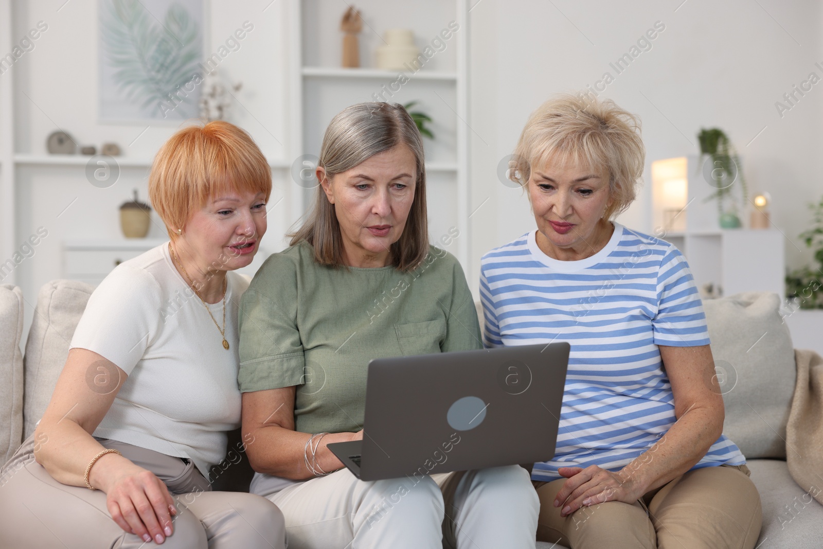 Photo of Friendship. Senior women watching something on laptop at home