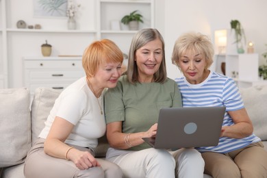 Photo of Friendship. Senior women watching something on laptop at home