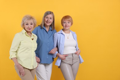 Photo of Friendship. Portrait of senior women on orange background, space for text