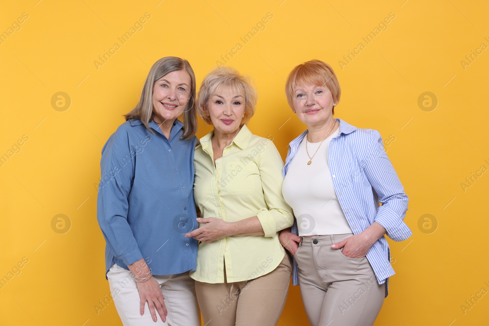 Photo of Friendship. Portrait of senior women on orange background