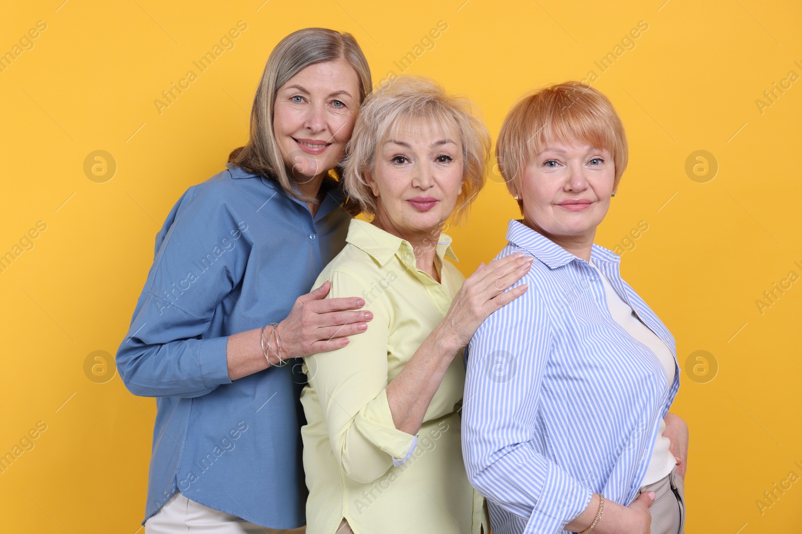 Photo of Friendship. Portrait of senior women on orange background