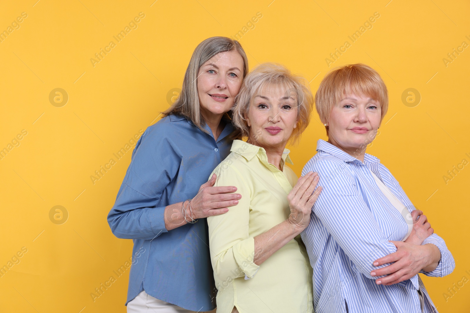 Photo of Friendship. Portrait of senior women on orange background