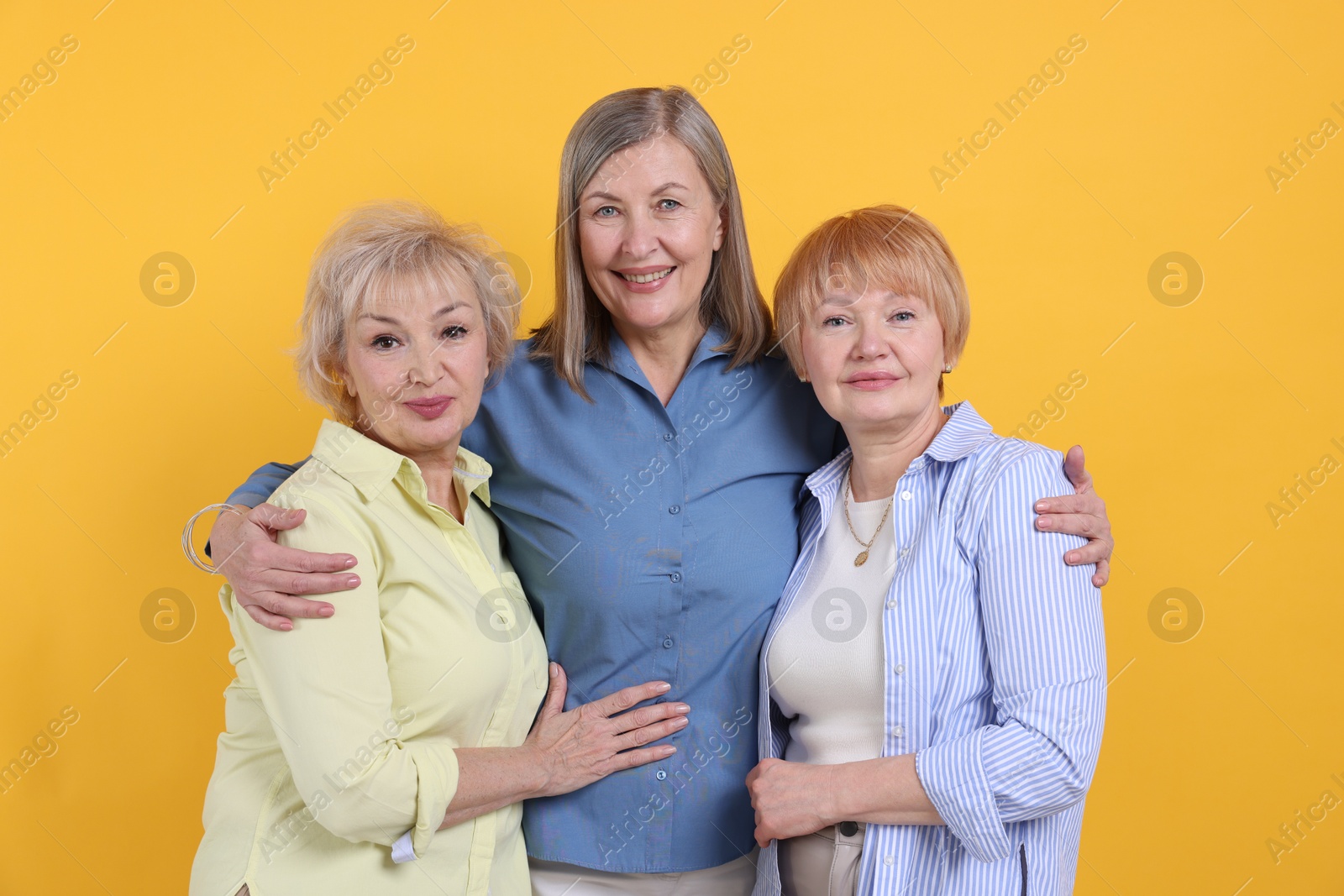 Photo of Friendship. Portrait of senior women on orange background