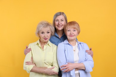 Photo of Friendship. Portrait of senior women on orange background