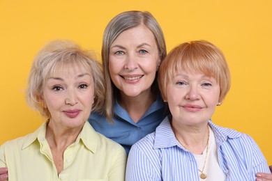 Photo of Friendship. Portrait of senior women on orange background