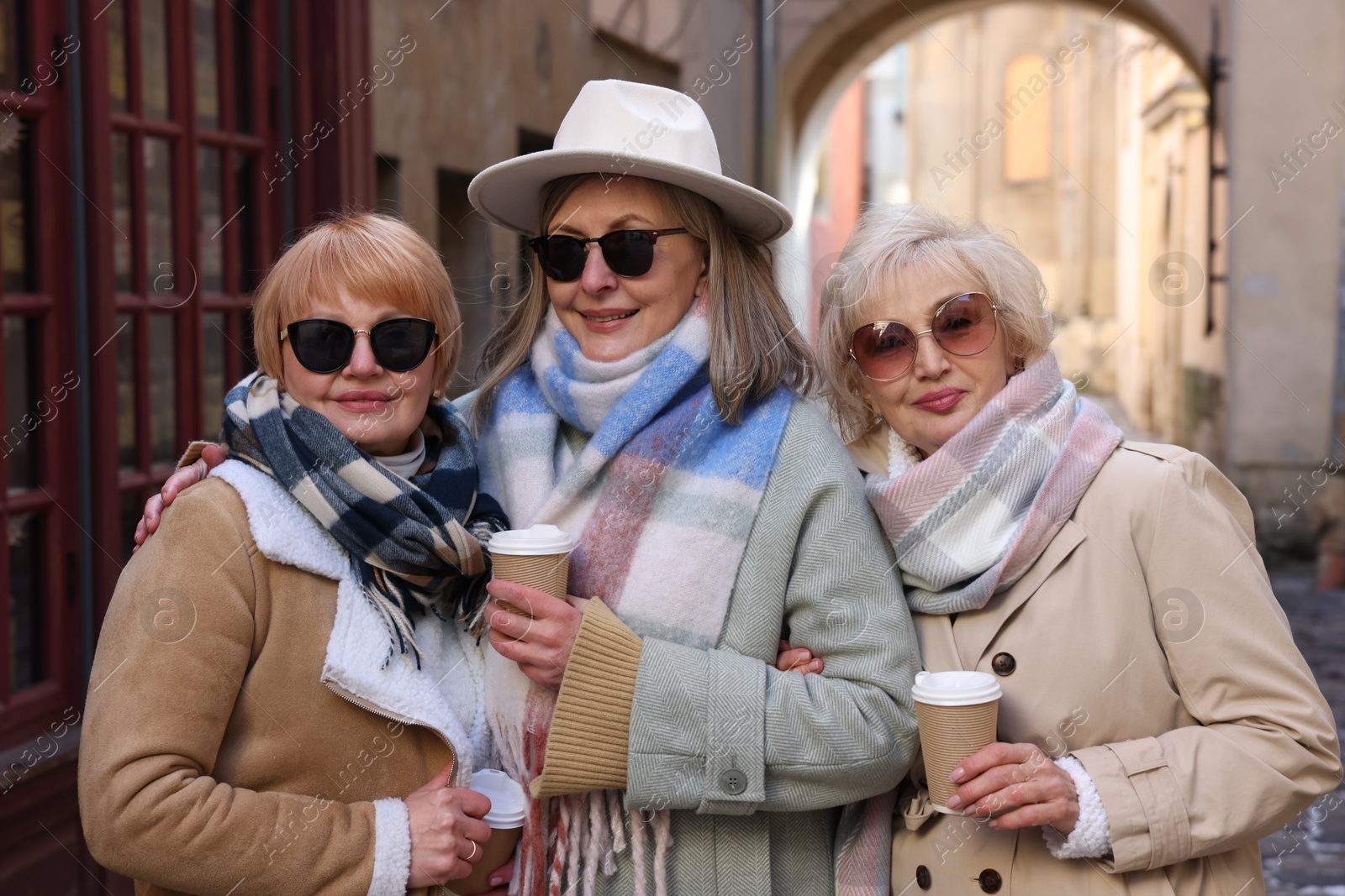 Photo of Friendship. Senior women enjoying hot drinks on city street