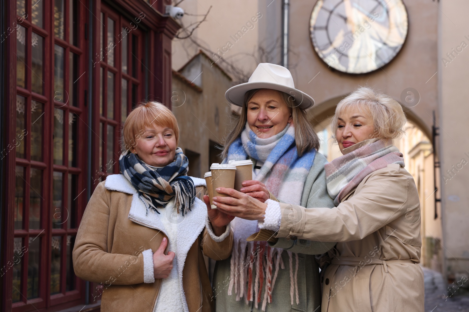 Photo of Friendship. Senior women enjoying hot drinks on city street