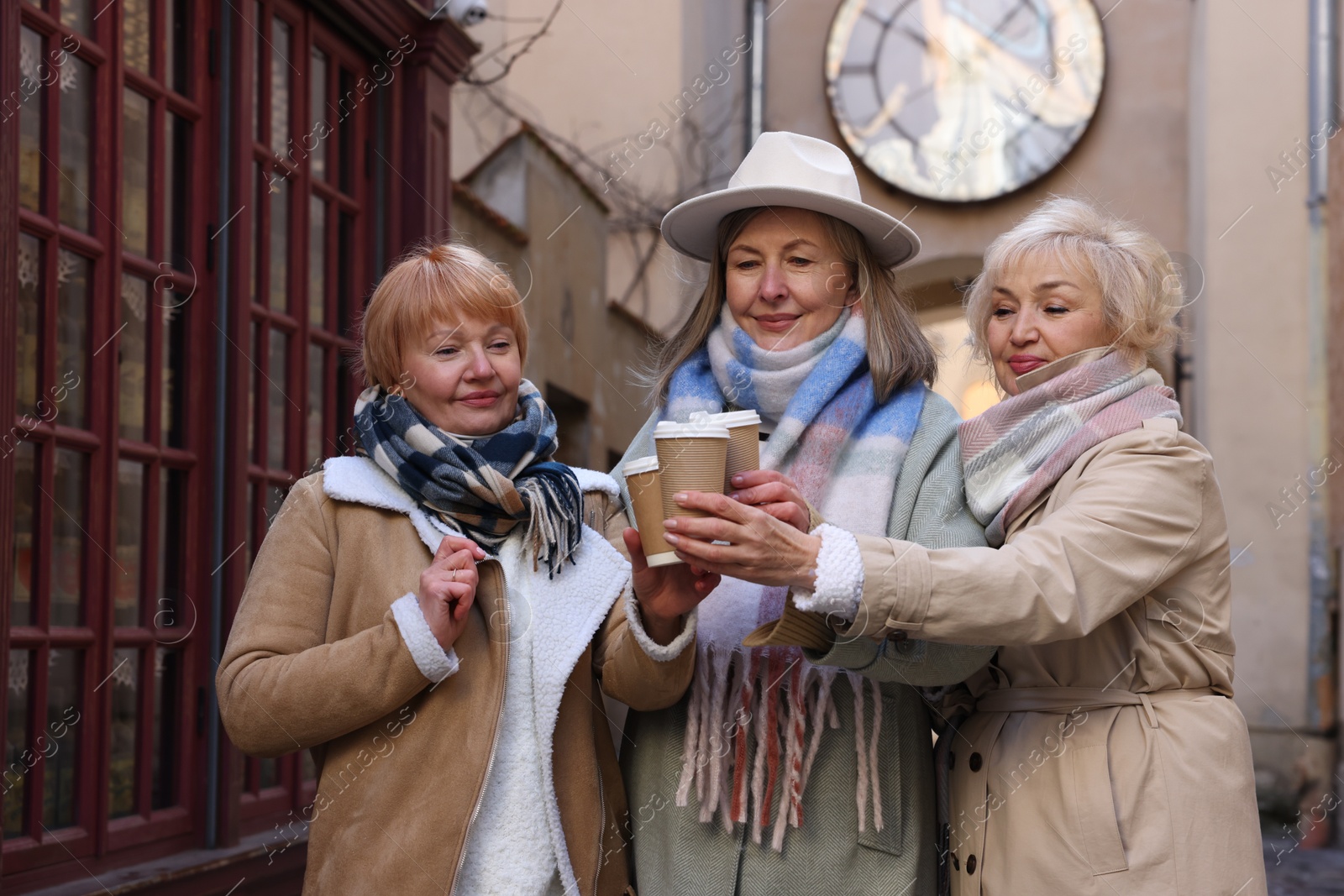 Photo of Friendship. Senior women enjoying hot drinks on city street