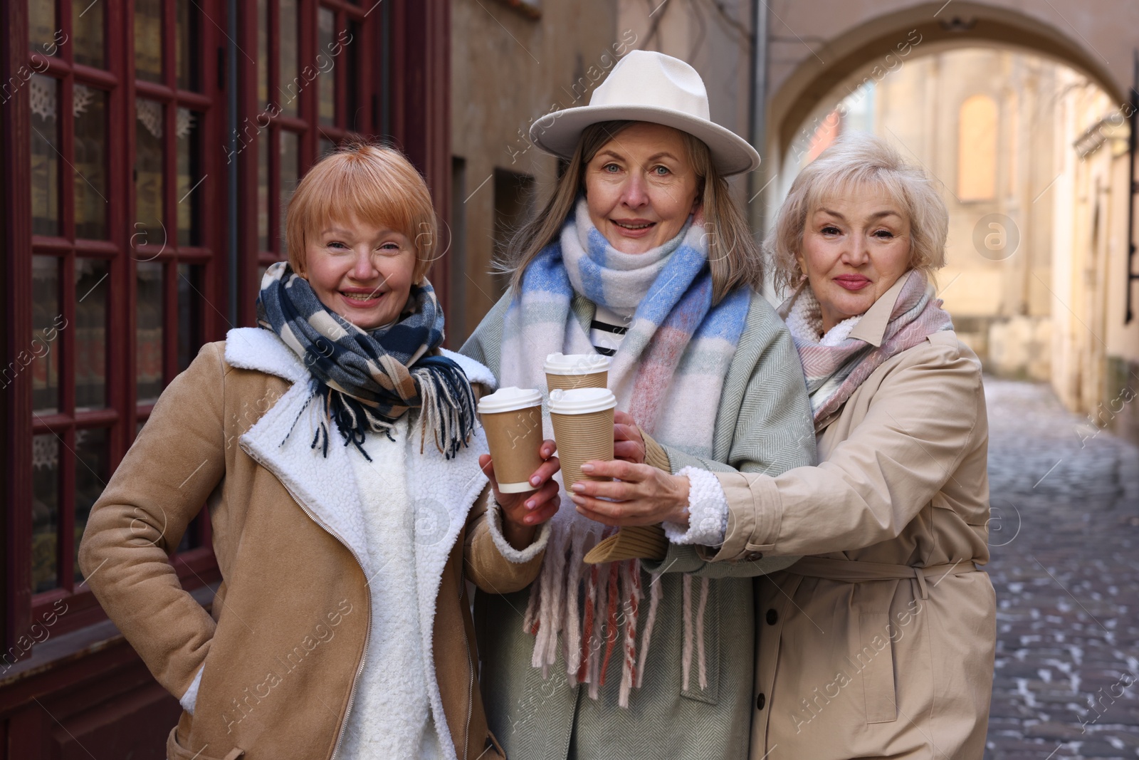 Photo of Friendship. Senior women enjoying hot drinks on city street