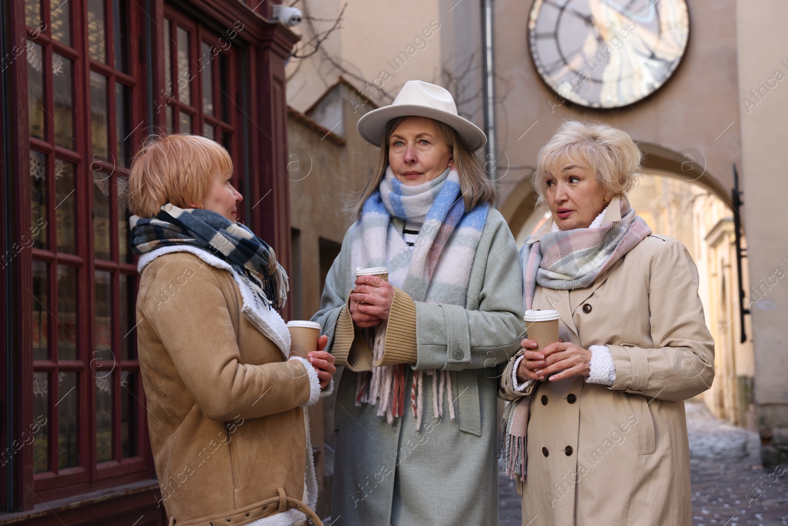 Photo of Friendship. Senior women enjoying hot drinks on city street