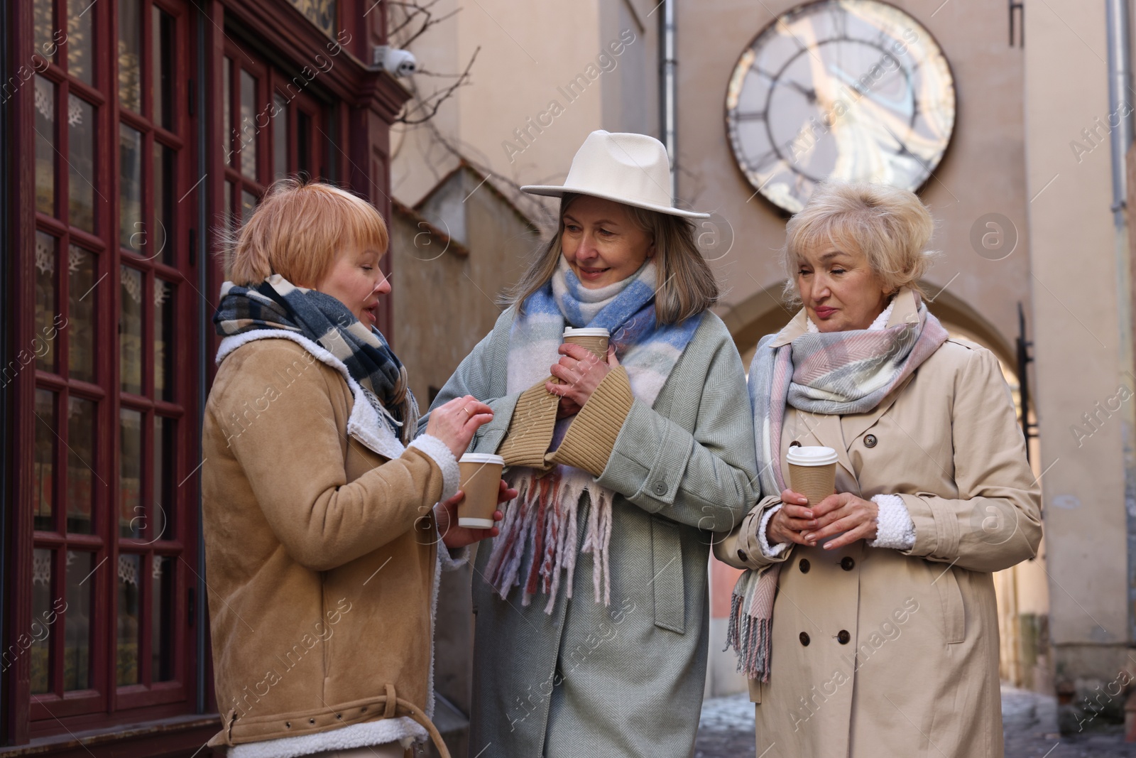 Photo of Friendship. Senior women enjoying hot drinks on city street