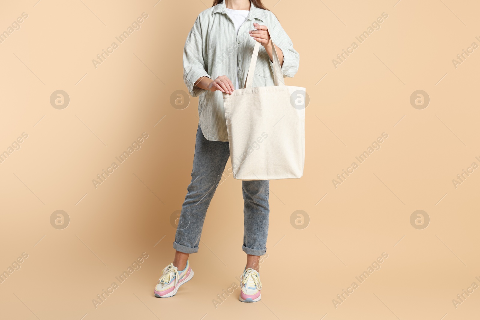 Photo of Woman with blank shopper bag on color background, closeup. Mockup for design