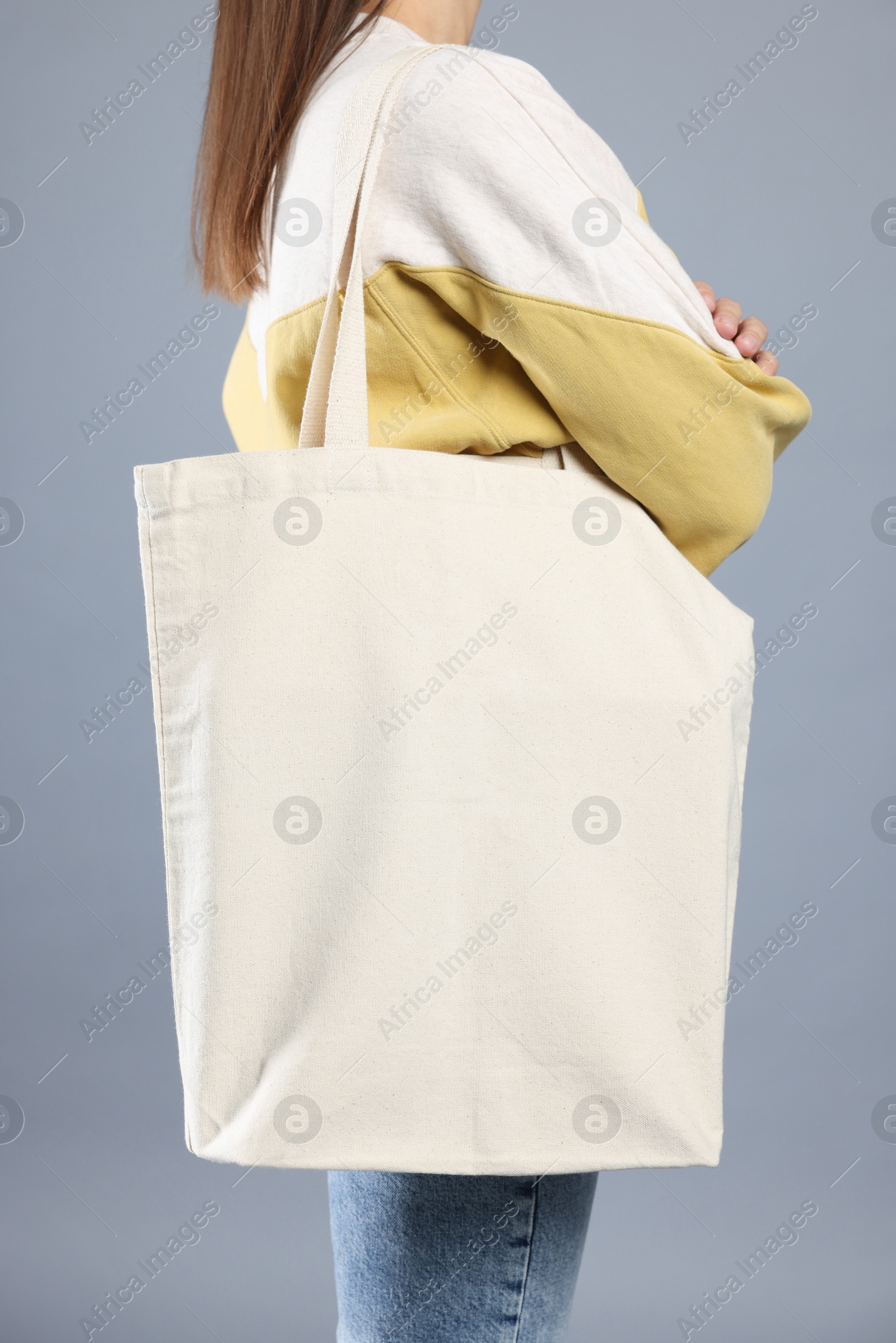 Photo of Woman with blank shopper bag on grey background, closeup. Mockup for design