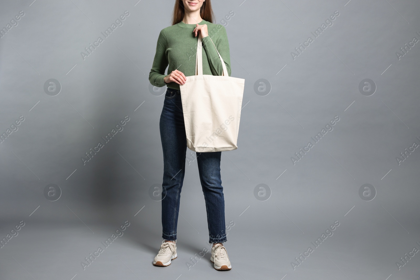 Photo of Woman with blank shopper bag on grey background, closeup. Mockup for design