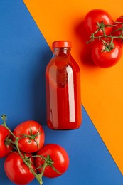 Photo of Tasty ketchup and tomatoes on color background, flat lay