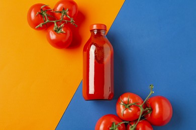 Photo of Tasty ketchup and tomatoes on color background, flat lay