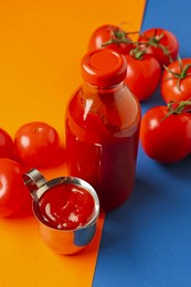 Photo of Tasty ketchup and tomatoes on color background, closeup