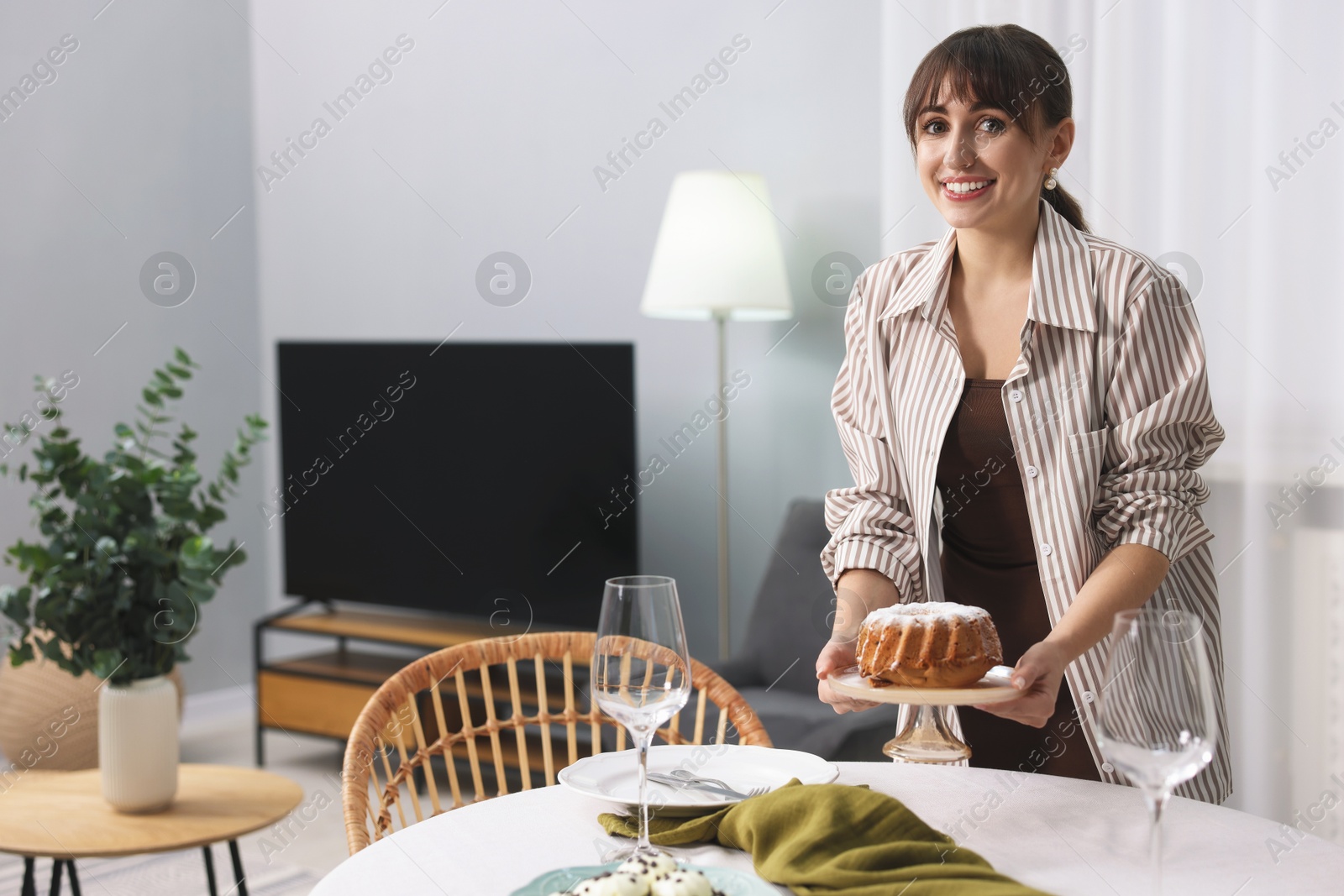 Photo of Woman setting table for dinner at home