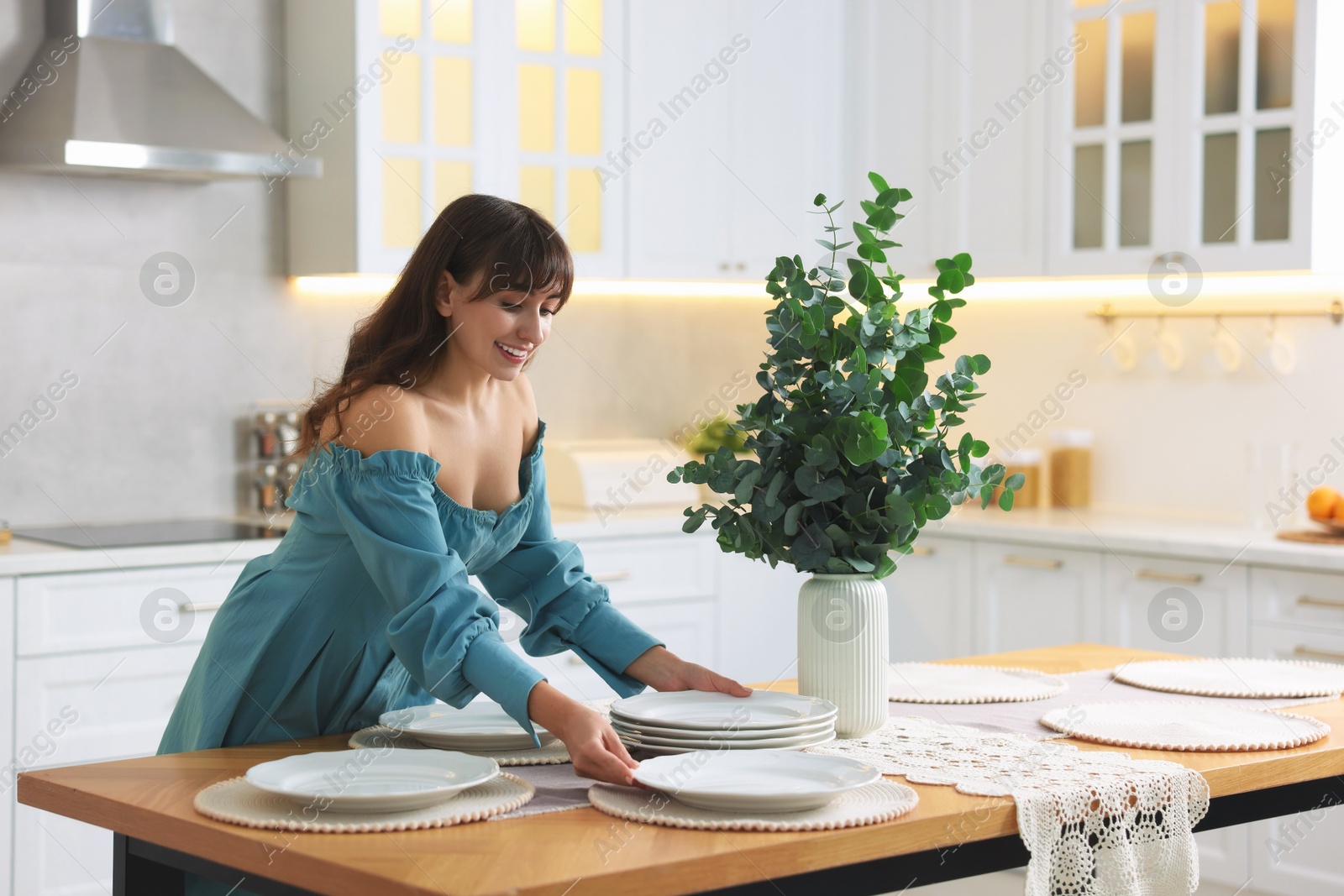 Photo of Woman setting table for dinner at home