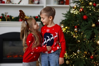 Adorable little kids near Christmas tree at home