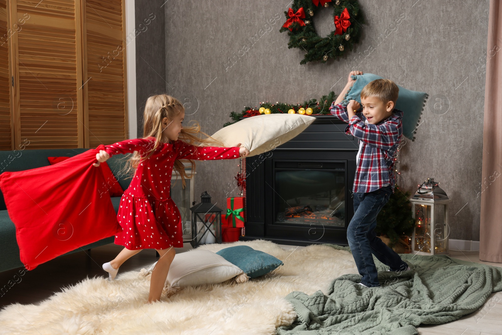 Photo of Little children having pillow fight at home. Christmas season