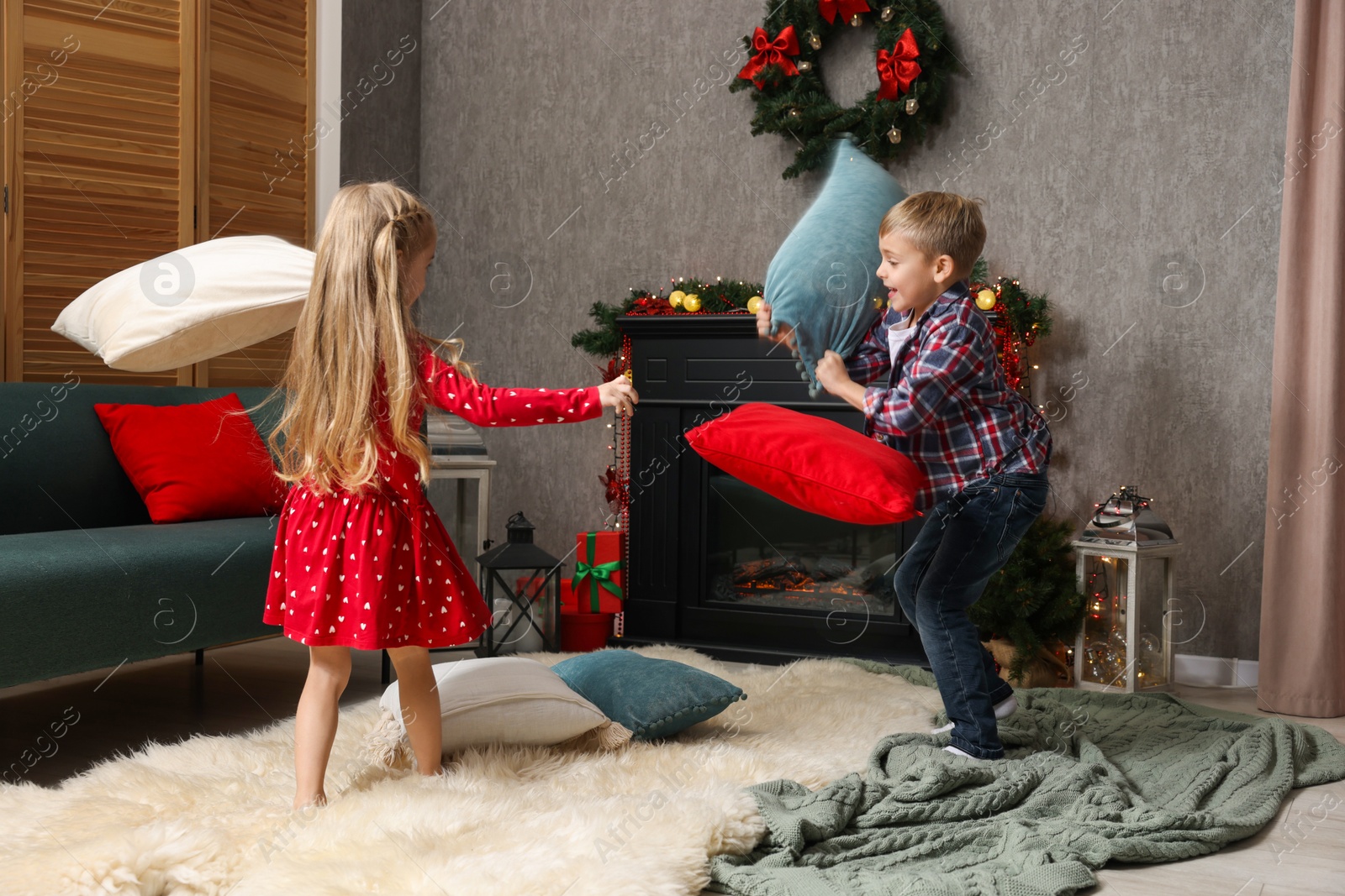 Photo of Little children having pillow fight at home. Christmas season