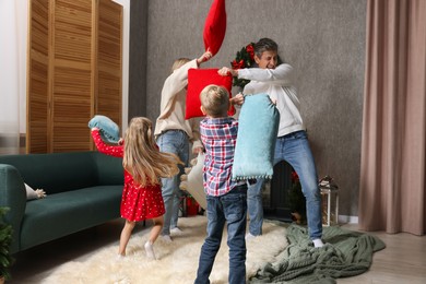 Family having pillow fight at home. Christmas season