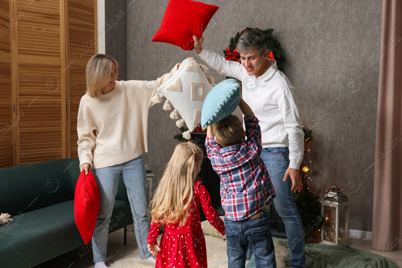 Photo of Family having pillow fight at home. Christmas season