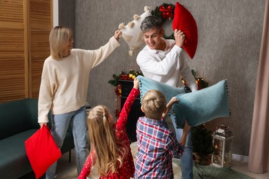 Family having pillow fight at home. Christmas season