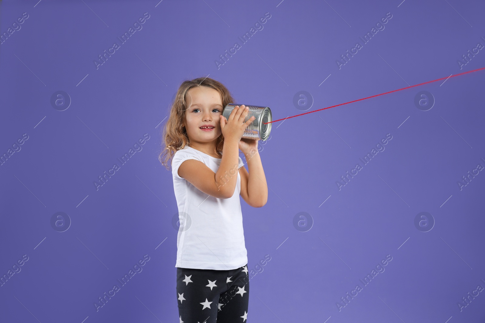 Photo of Girl using tin can telephone on violet background