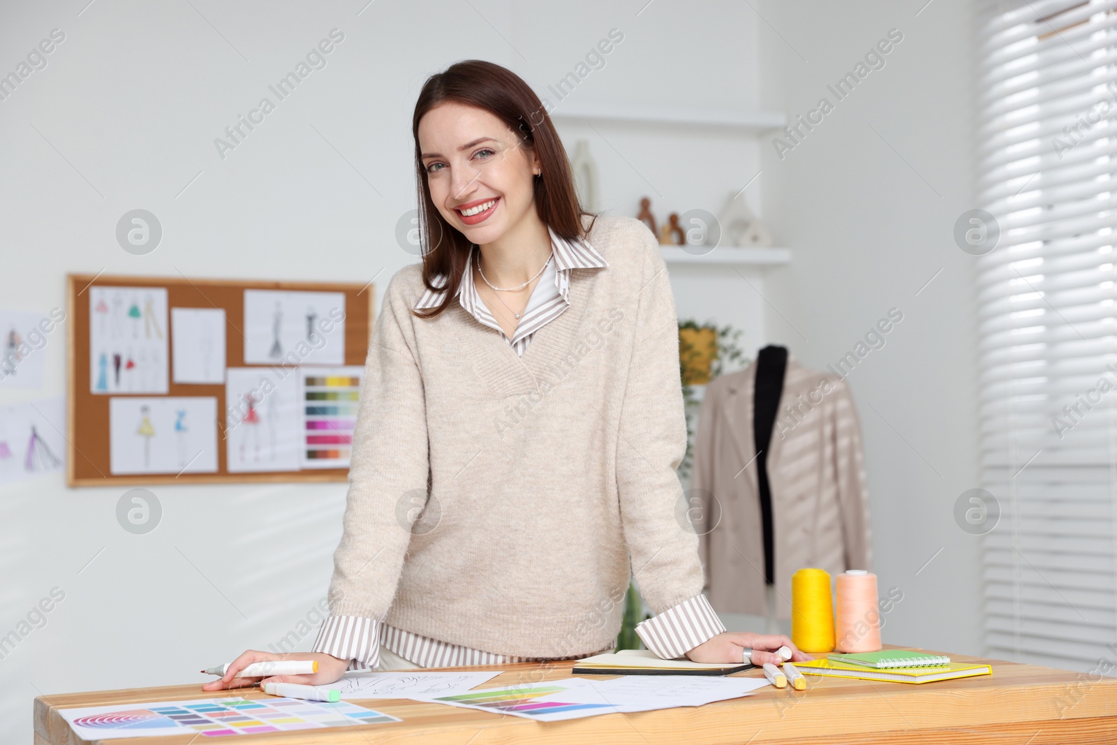 Photo of Fashion designer working at wooden table in workshop