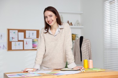 Photo of Fashion designer working at wooden table in workshop