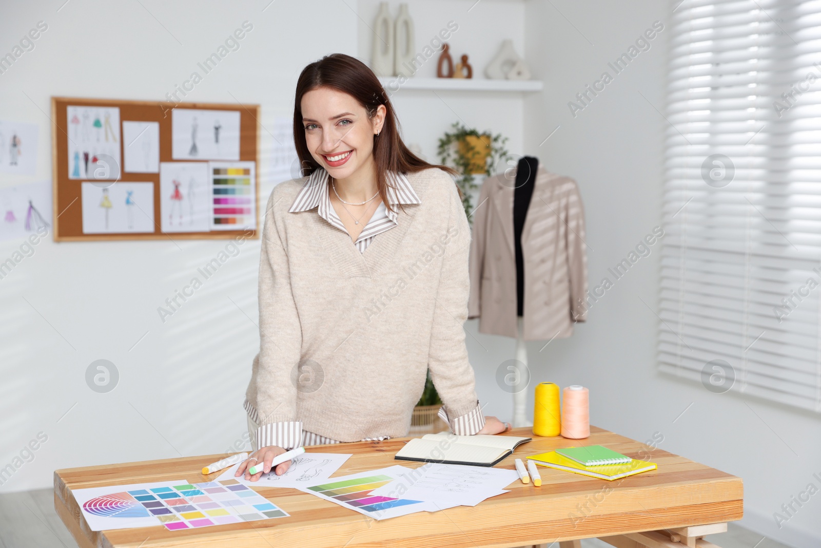 Photo of Fashion designer working at wooden table in workshop