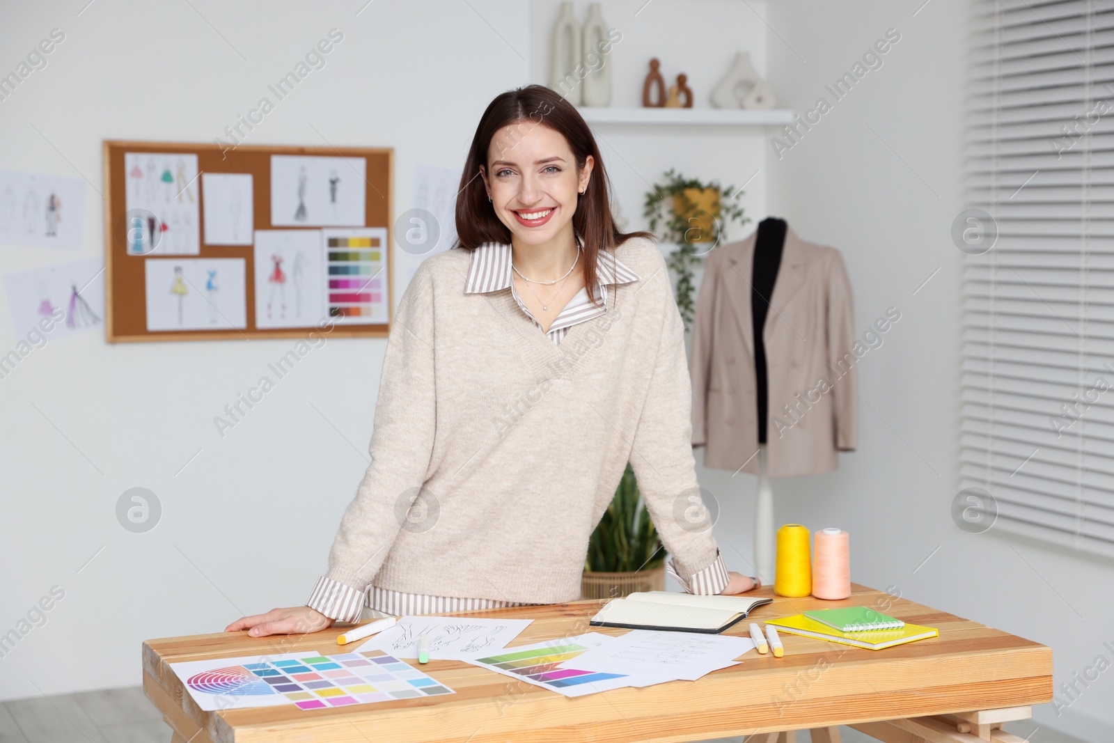 Photo of Fashion designer working at wooden table in workshop