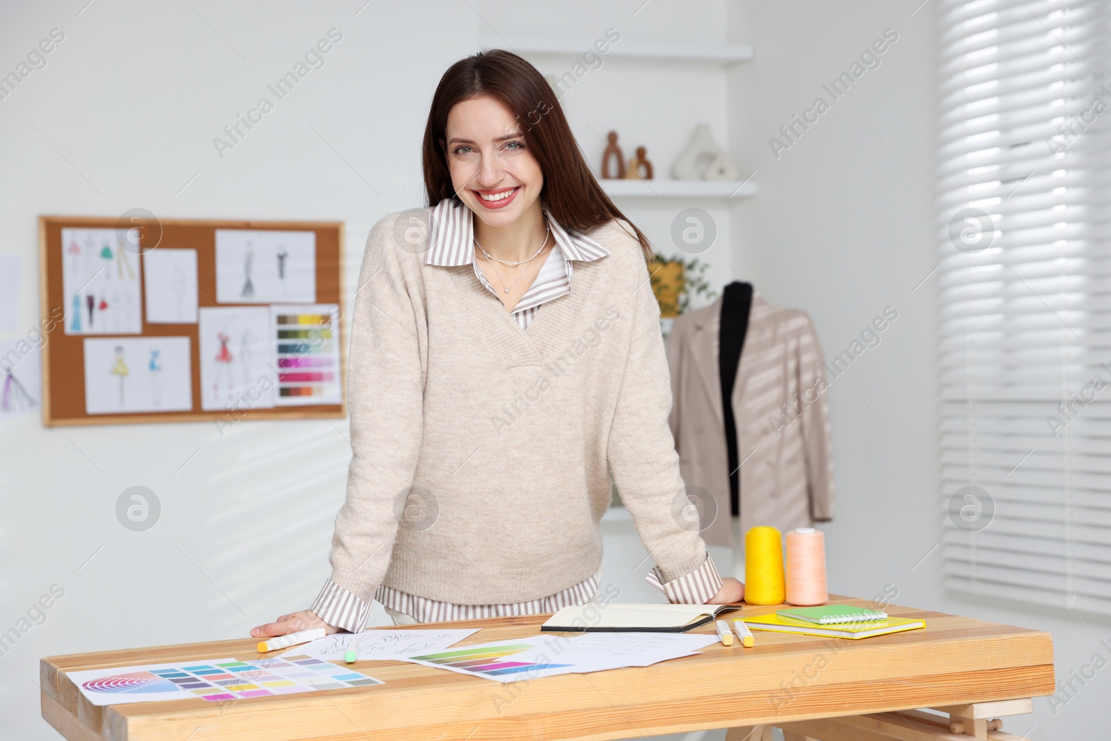 Photo of Fashion designer working at wooden table in workshop