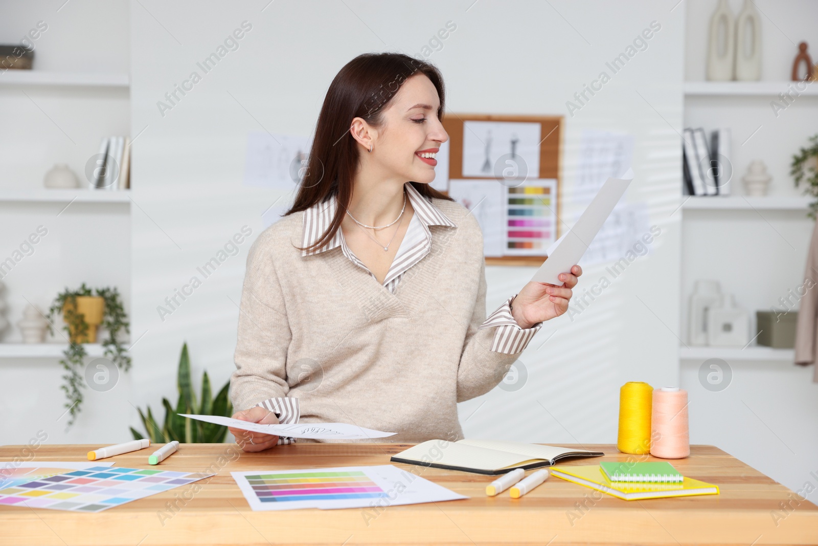 Photo of Fashion designer working at wooden table in workshop