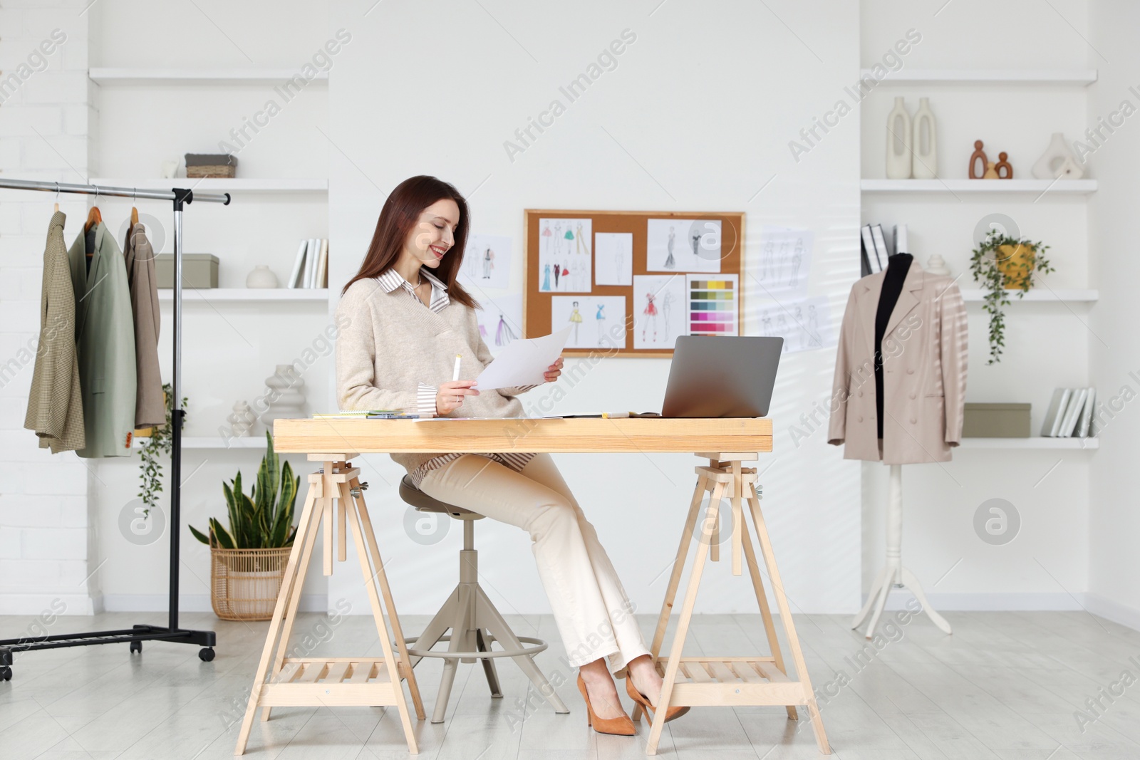 Photo of Fashion designer working at wooden table in workshop