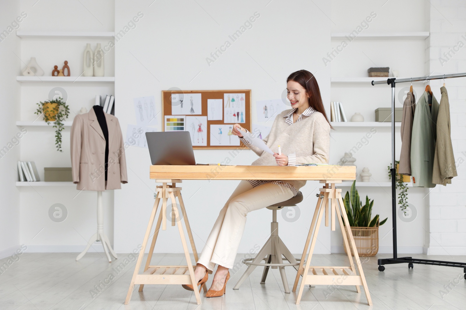 Photo of Fashion designer working at wooden table in workshop