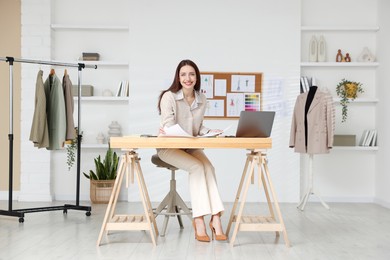 Photo of Fashion designer working at wooden table in workshop