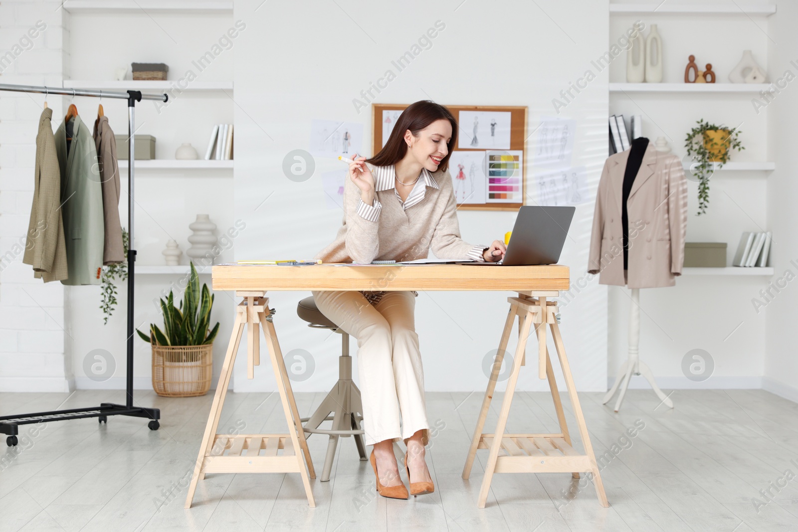 Photo of Fashion designer working at wooden table in workshop