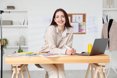 Photo of Fashion designer working at wooden table in workshop