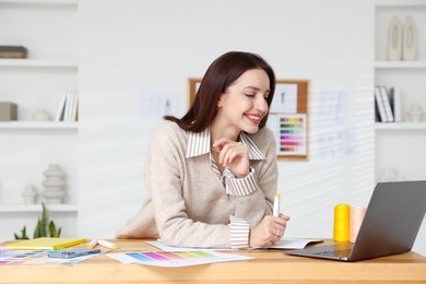 Photo of Fashion designer working at wooden table in workshop