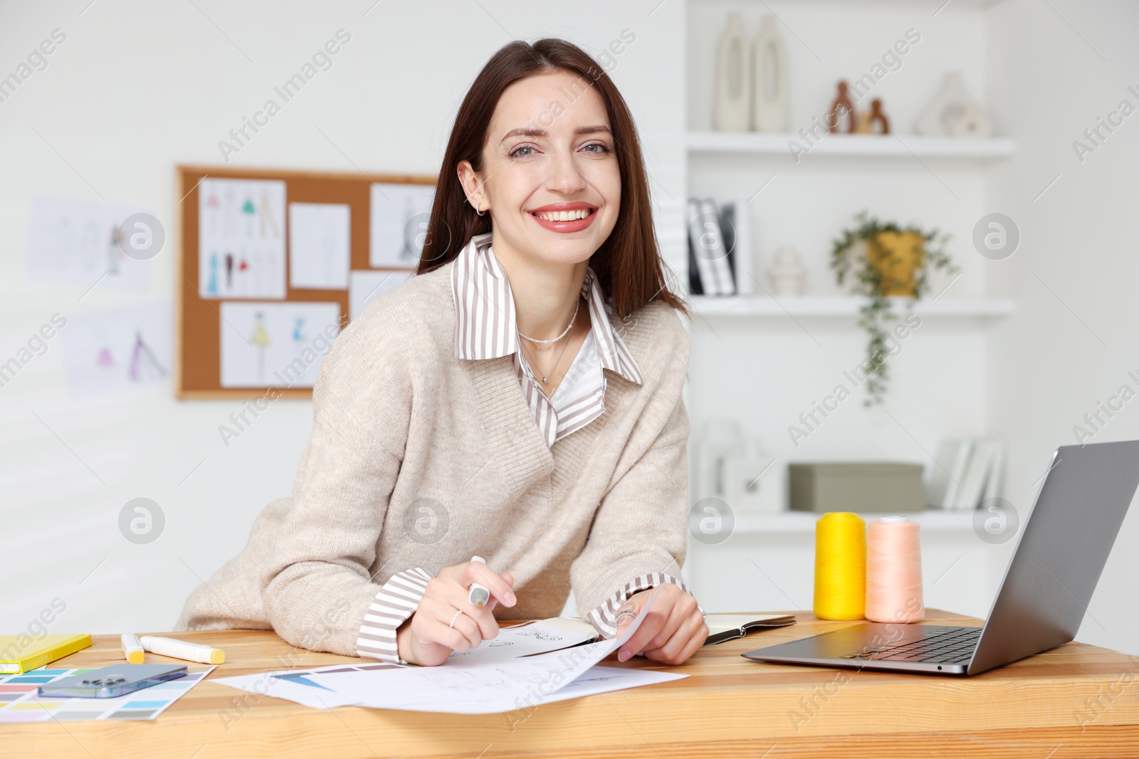 Photo of Fashion designer working at wooden table in workshop