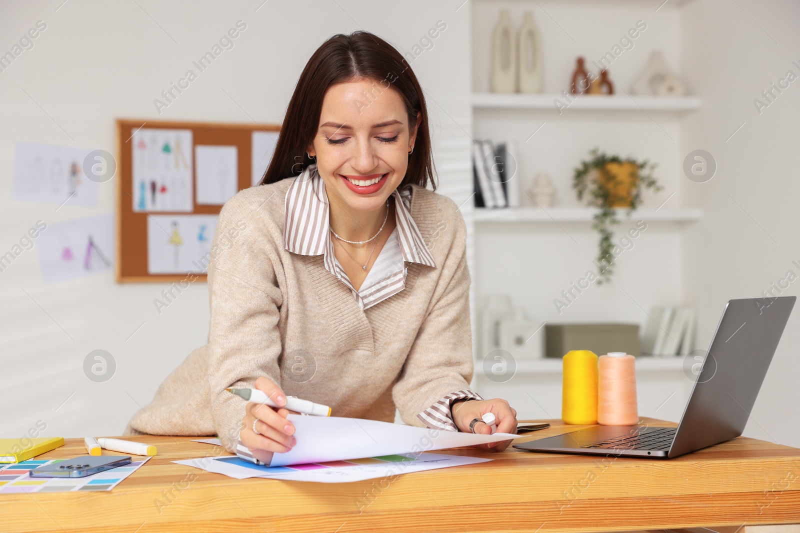 Photo of Fashion designer working at wooden table in workshop